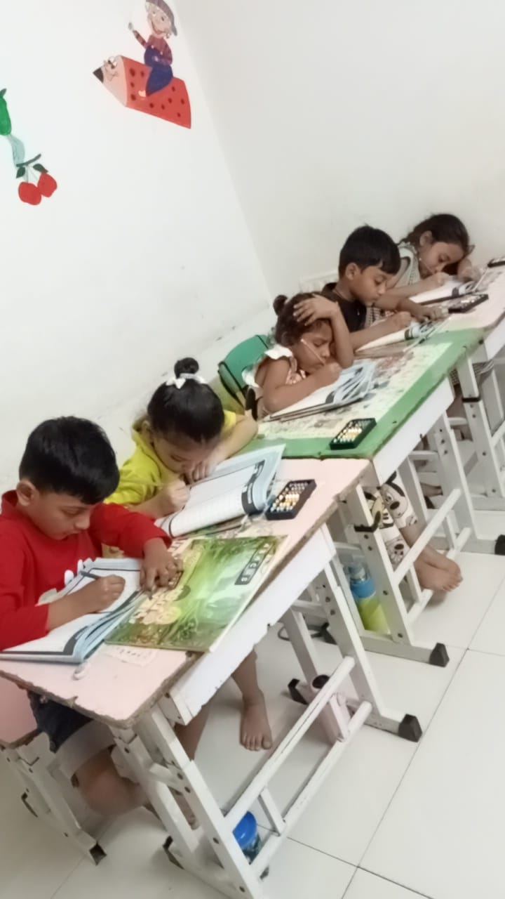 Students writing and practicing with abacus at their desks